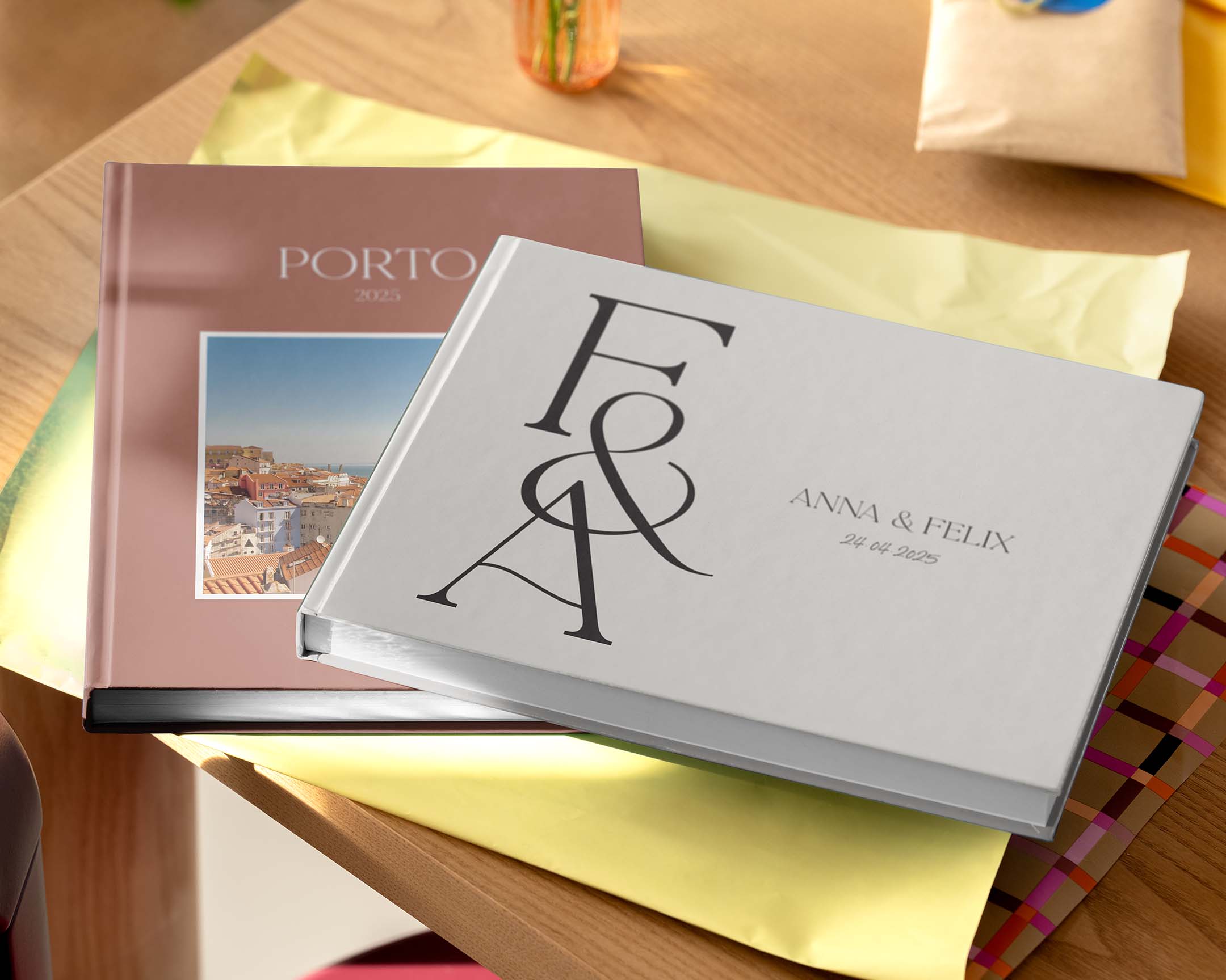 Zwei personalisierte Fotobücher in verschiedenen Größen und Designs auf einem Tisch.