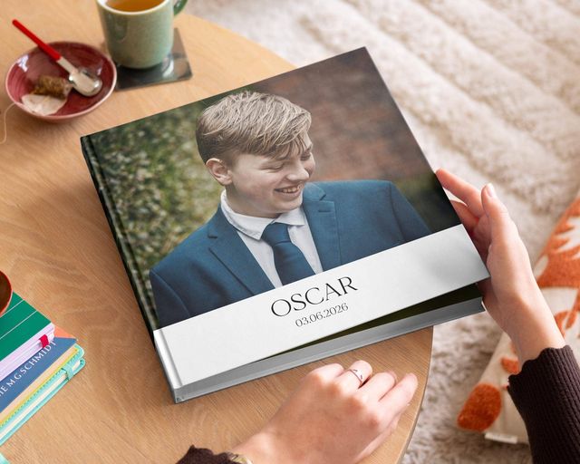 Geöffnetes Fotobuch für die Erstkommunion mit Kinderbildern