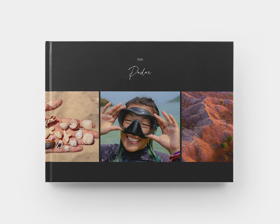 Ein geschlossenes Hardcover-Fotobuch im Querformat mit Sommerfotos auf dem Cover.