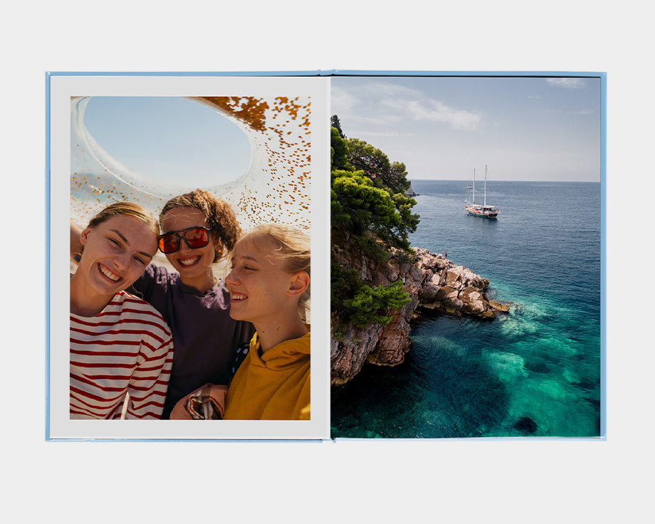Ein großes Hochformat-Fotobuch mit einem Foto einer Person an einem Bergsee.