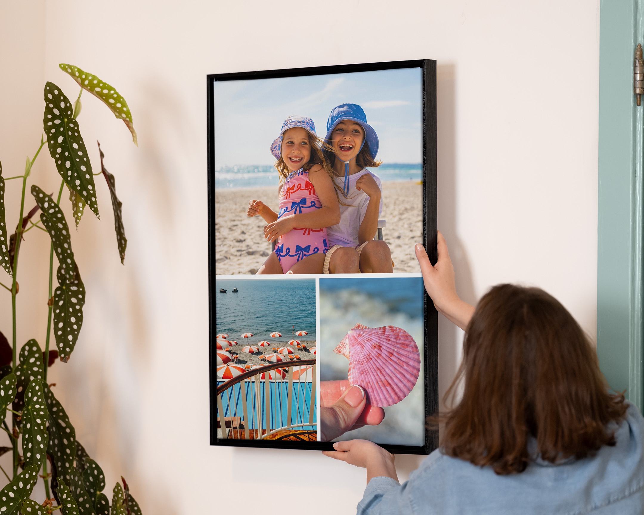 Person, die eine gerahmte Collage aufhängt