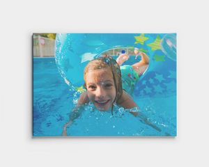 Foto auf Leinwand eines Kindes, das im Pool unter Wasser schwimmt.