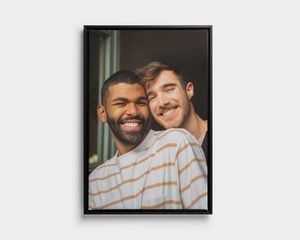 Schwarz gerahmtes Porträt zweier lächelnder Männer als Foto auf Leinwand.